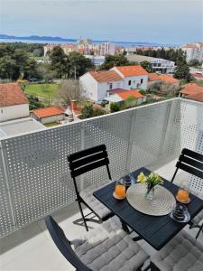 Un patio con una mesa y sillas en un balcón. en Apartman Lovre, en Zadar