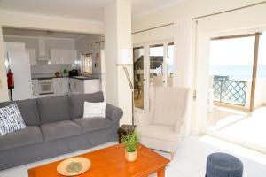 a living room with a couch and a table at Sunset Paradise in Armação de Pêra