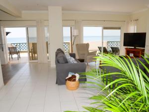 a living room with a couch and a television at Sunset Paradise in Armação de Pêra