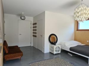una camera con letto, sedia e lampadario a braccio di Vintage studio am Chiemsee a Übersee