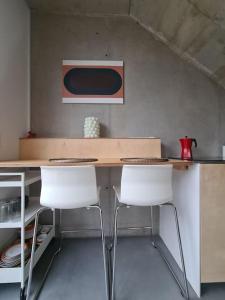 una cucina con tavolo e due sedie bianche di Vintage studio am Chiemsee a Übersee