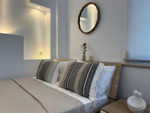 a bedroom with a bed with a mirror on the wall at Calm Joy & J - Bee in Ermoupoli