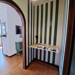 un couloir avec une chambre à rayures vertes et blanches dans l'établissement La casa di Guia, à Perledo