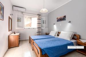 sypialnia z łóżkiem z niebieskim kocem w obiekcie Matsas House & Studio w mieście Paleokastritsa