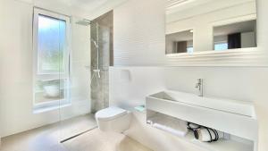 a white bathroom with a sink and a toilet at Nautilus-Bay Suites - Dreizimmer Suite 420 in Zavala +30 photos