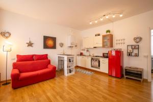 een woonkamer met een rode bank en een keuken bij Porta Torre suite - Como Lake city center - Free parking , air conditioning in Como