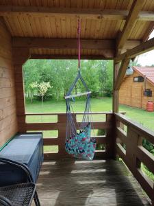 a hammock on a screened in porch with a swing at Domki na zaciszu w Rynie in Ryn
