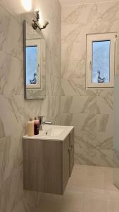 bagno con lavandino e specchio di The Acropolis Cave Apartment ad Atene