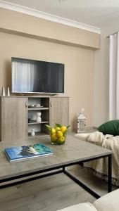 a living room with a bowl of fruit on a coffee table at The Acropolis Cave Apartment in Athens