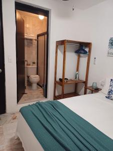 a bedroom with a bed and a bathroom with a toilet at Casa Las Palmas in Cancún
