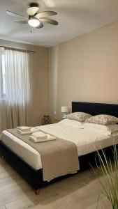 a bedroom with a large bed with a ceiling fan at The Acropolis Cave Apartment in Athens