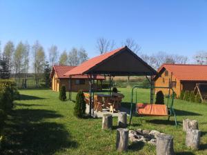 a park with a house and a playground at Domki na zaciszu w Rynie in Ryn