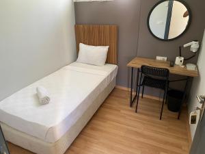 Kleines Zimmer mit einem Bett und einem Schreibtisch. in der Unterkunft Turunç Hotel ANTALYA in Antalya
