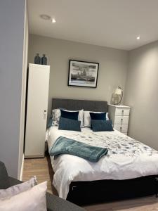 een slaapkamer met een groot bed met blauwe kussens bij Sweet Swan House in Rickmansworth