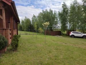 a yard with a car parked next to a house at Domki na zaciszu w Rynie in Ryn