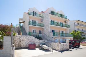 um grande edifício com uma parede de pedra e escadas em Apartments Marija Bibić em Hvar