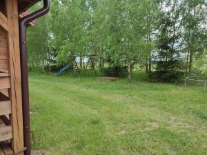 a yard with a playground and a swing set at Domki na zaciszu w Rynie in Ryn