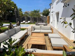 eine Terrasse mit Sofas, einem Tisch und Stühlen in der Unterkunft Maison de famille avec piscine in Beaussais sur Mer