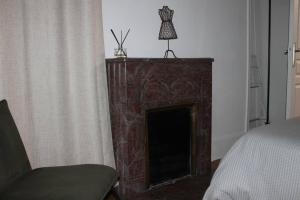 a fireplace in a bedroom with a chair and a bed at Chartres hyper centre bel appartement rénové in Chartres