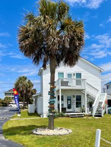 a palm tree in front of a white house at Waterway Inn in Cedar Point