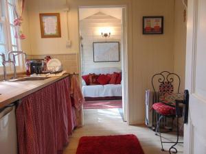 a kitchen with a sink and a room with a bed at Romany Wagon & Cwtch in Llandysul