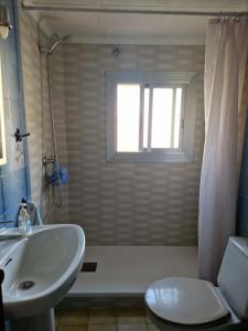 a bathroom with a sink and a toilet and a window at Apartamento cerca del centro in Vilanova i la Geltrú