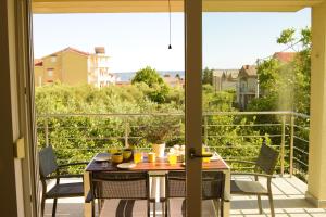 a patio with a table and chairs and a view of a balcony at Apartments Villa Ornamenta in Kaštela