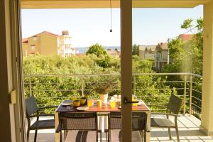 a patio with a table and chairs and a view of a balcony at Apartments Villa Ornamenta - 5min to beach - free parking in Kaštela +60 photos