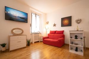 een woonkamer met een rode stoel en een tv bij Porta Torre suite - Como Lake city center - Free parking , air conditioning in Como