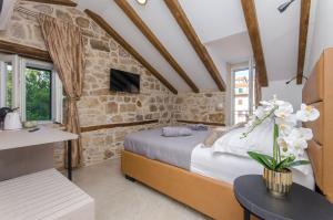 斯普利特Rio Luxury Rooms的一间带床和石墙的卧室