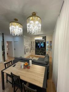 a living room with a dining table and chandeliers at Confortable, au centre-ville in Saint-Claude
