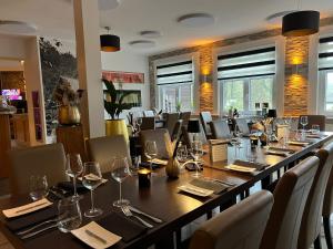 a large long table in a restaurant with wine glasses at Hotel-Restaurant Jagdhaus Heede in Hannoversch Münden