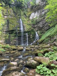a waterfall on the side of a mountain with rocks at Confortable, au centre-ville in Saint-Claude +10 photos