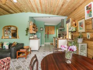 a living room with a table and a kitchen at Lulu Logs in Bristol