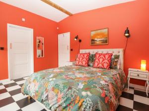 a bedroom with orange walls and a large bed at Lulu Logs in Bristol