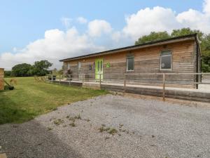 a wooden cabin with a green door in a field at Lulu Logs in Bristol