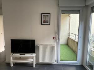 a living room with a flat screen tv on a wall at T5 4 chambres Gratte ciel, Villeurbanne, meublé in Villeurbanne