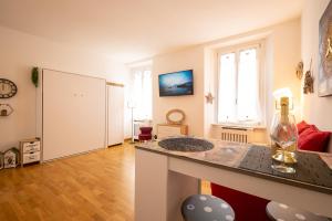 a kitchen and living room with a counter and a window at PortaTorre Suite, a Charming apartment in the Heart of Como, Free Private Parking, Air Conditioning & More! in Como