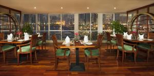 een restaurant met tafels en stoelen en uitzicht op de stad bij Golden Tulip Hotel Apartments in Sharjah