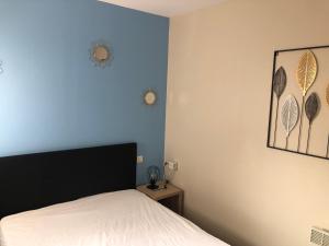 une chambre avec un lit et un mur bleu dans l'établissement T2 Alba Rossa n 141 Confort, Panorama Mer Incroyable, à Serra-di-Ferro