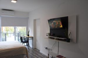 ブエノスアイレスにある@juanbjustoapartamentoのベッドルーム1室(ベッド1台、壁掛けテレビ付)