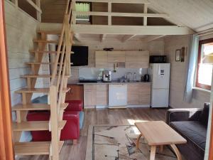 a kitchen and a staircase in a tiny house at Domki na zaciszu w Rynie in Ryn