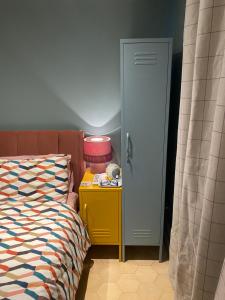 a bedroom with a bed and a yellow table next to a door at Studio 22 in Harrogate