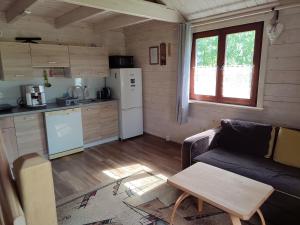 a living room with a couch and a kitchen at Domki na zaciszu w Rynie in Ryn