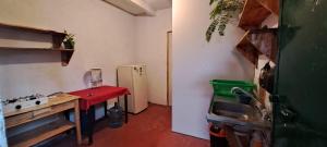 a small kitchen with a red table and a sink at Casa Deja-vu in San Marcos La Laguna
