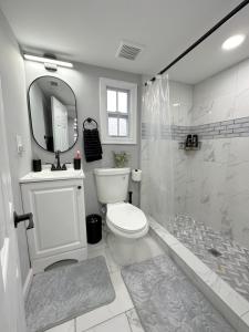 a white bathroom with a toilet and a shower at Cottage in Heart of Colonial Beach, 7 Mins Walk to the Beach in Colonial Beach