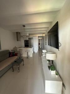 a living room with a couch and a tv on a wall at Sun club playa del águila by la piedra viva in San Bartolomé de Tirajana