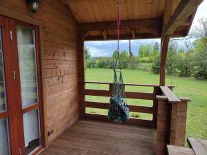 a porch of a log cabin with a porch swing at Domki na zaciszu w Rynie in Ryn