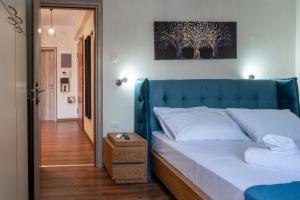 - un lit avec une tête de lit bleue dans l'établissement Luxury apartment overlooking the citadel of Tsakas, à Athènes