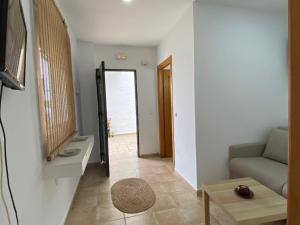 ein Wohnzimmer mit einem Sofa und einem Spiegel in der Unterkunft Alojamiento Rural Al´Mare in Conil de la Frontera
